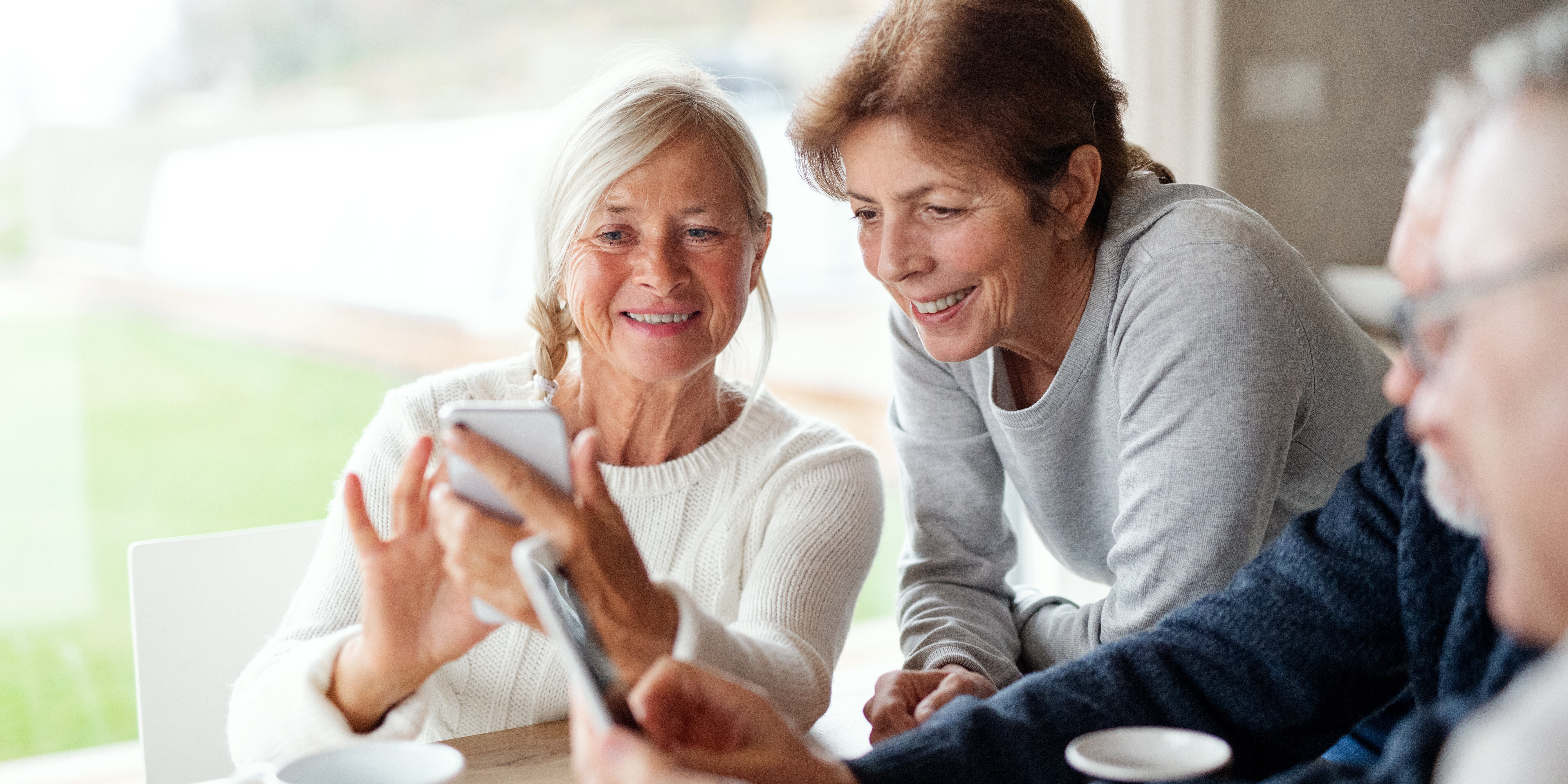 Zwei Rentner*innen erhalten eine Schulung bezüglich Umgang mit dem Smartphone