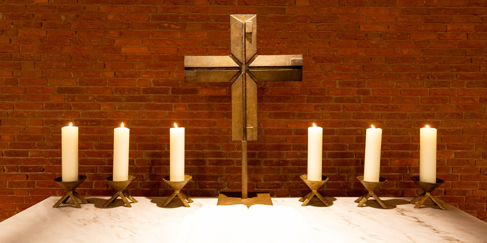 Altar der Kirche des Evangelischen Waldkrankenhauses Spandau mit Kreuz und Kerzen.