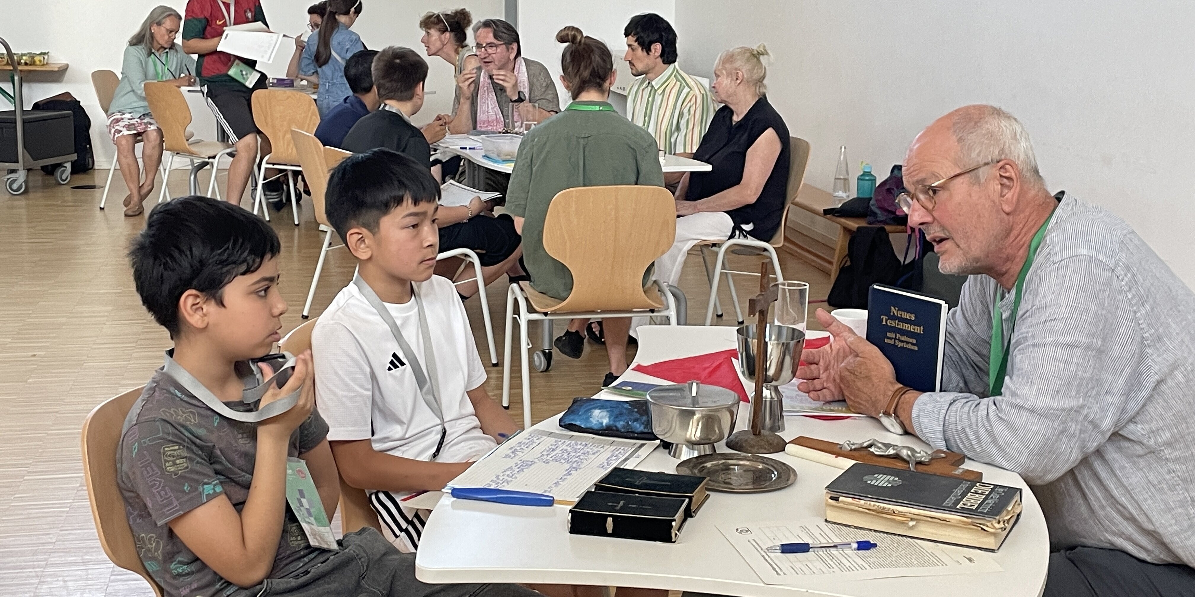 „Weltreligionen“ ist ein Projekt der Kampagne „Kinder beflügeln“ der Johannesstift Diakonie Schüler*innen sitzen in einem Klassenraum an mehreren Tischen