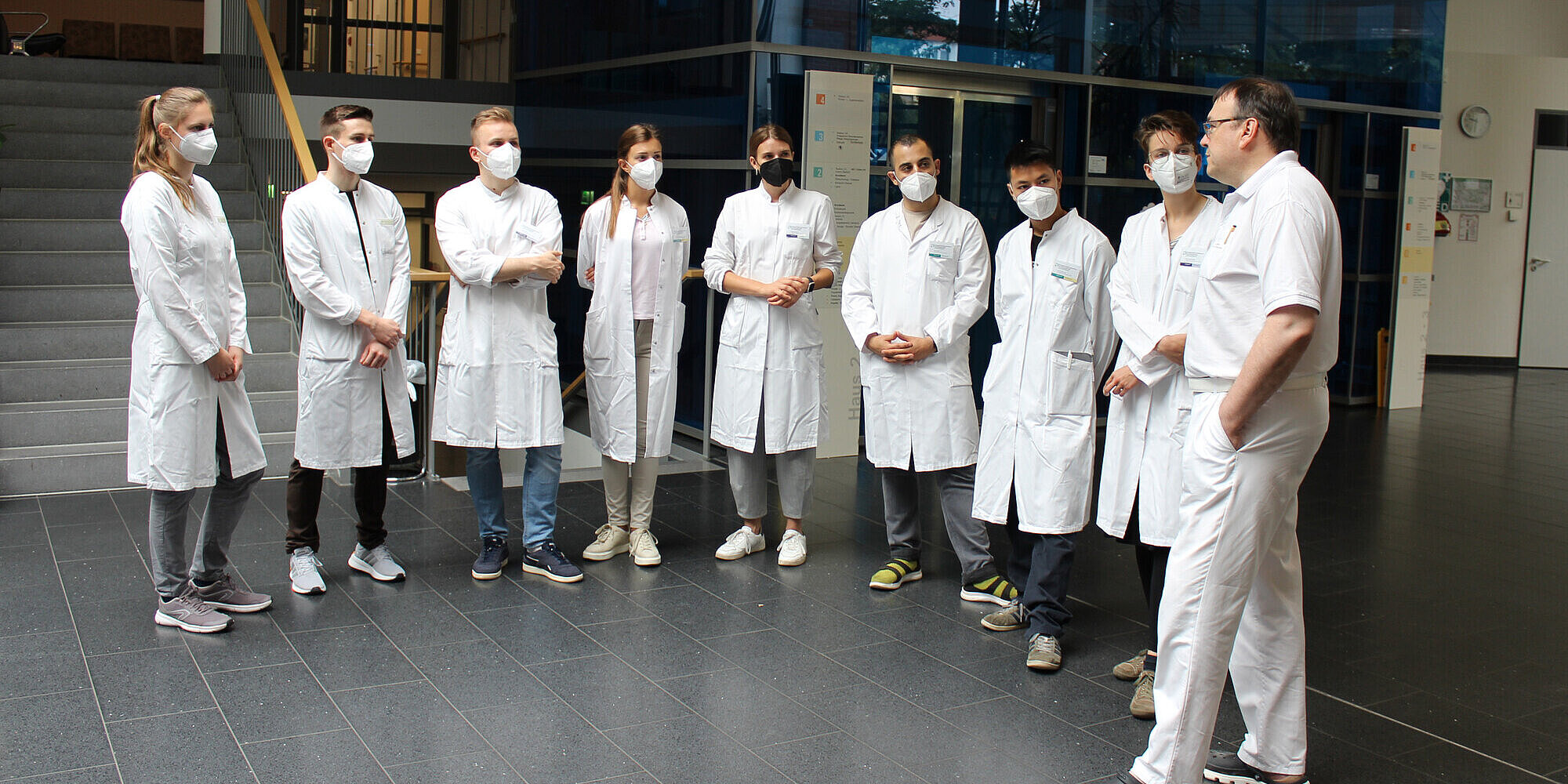 9 junge Menschen in Arztkleidung