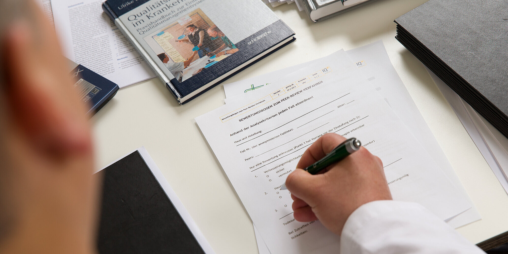 Mitarbeiter füllt einen auf dem Tisch liegenden Fragebogen aus.