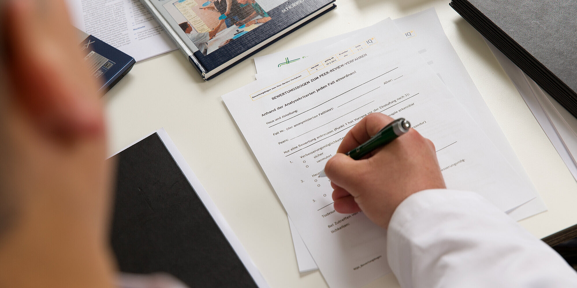 Mitarbeiter füllt einen auf dem Tisch liegenden Fragebogen aus.