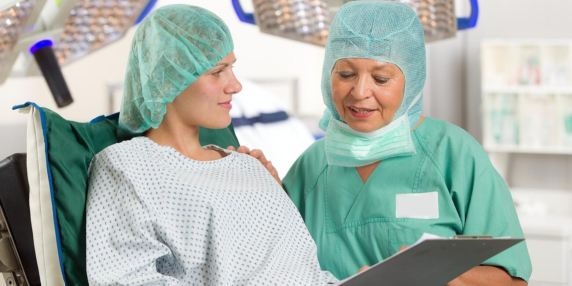 Allgemein-, Viszeral- und Gefäßchirurgie in Wittenberg Ärztin und Patientin im OP-Saal schauen auf einen Aufklärungsbogen.