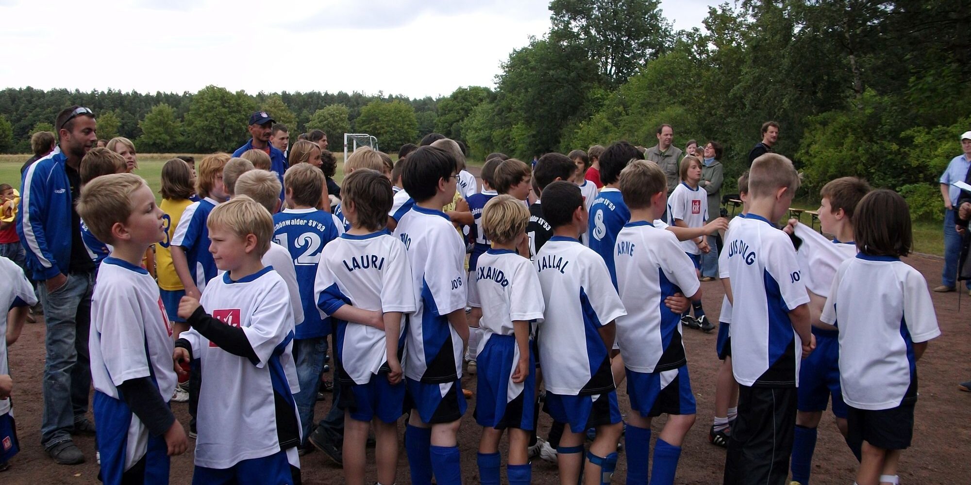 Eine Gruppe von Kindern in Fußballtrikots auf dem Sportplatz.
