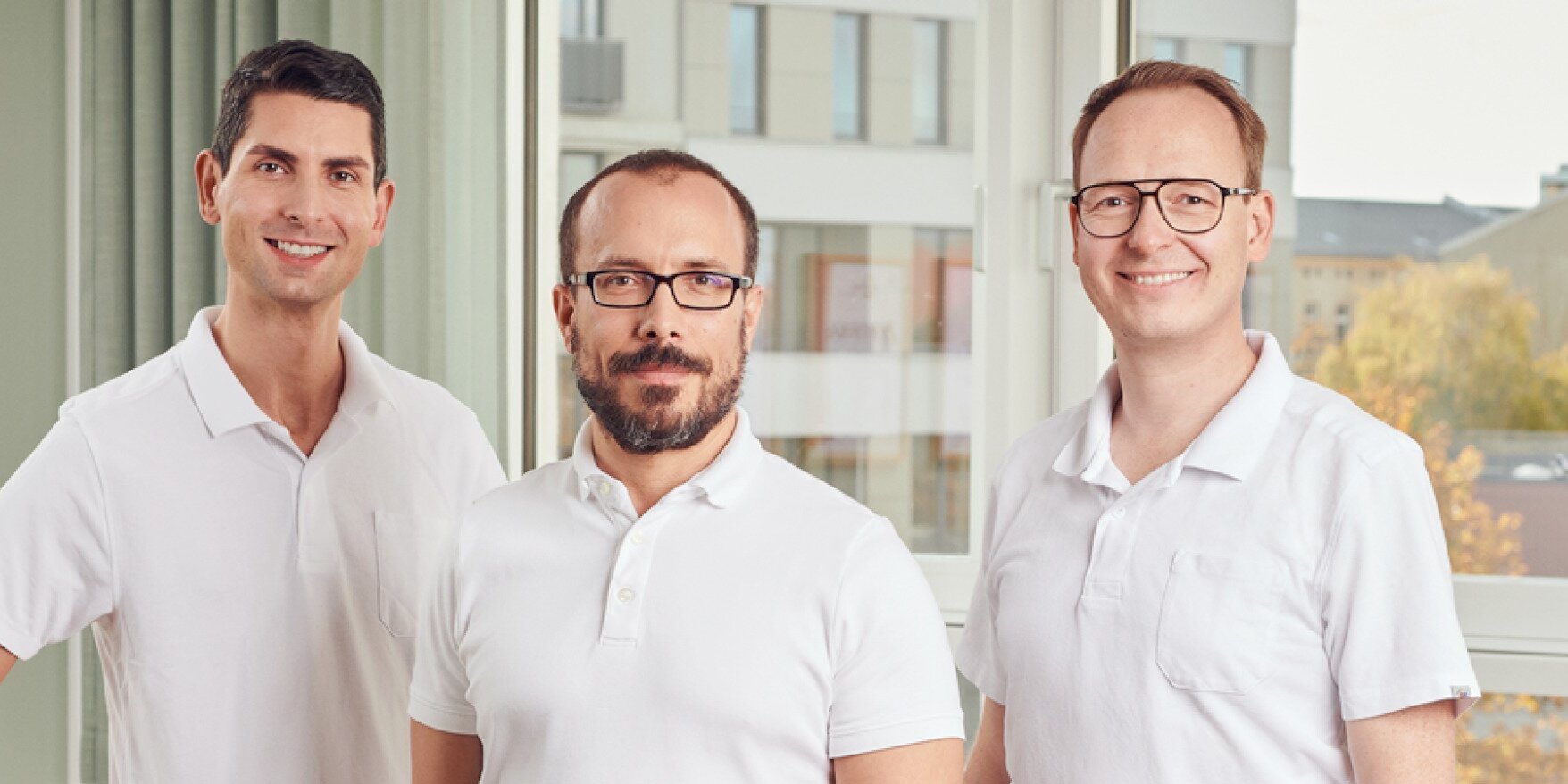 Teamfoto: Drei Ärzte in weißer Arbeitskleidung