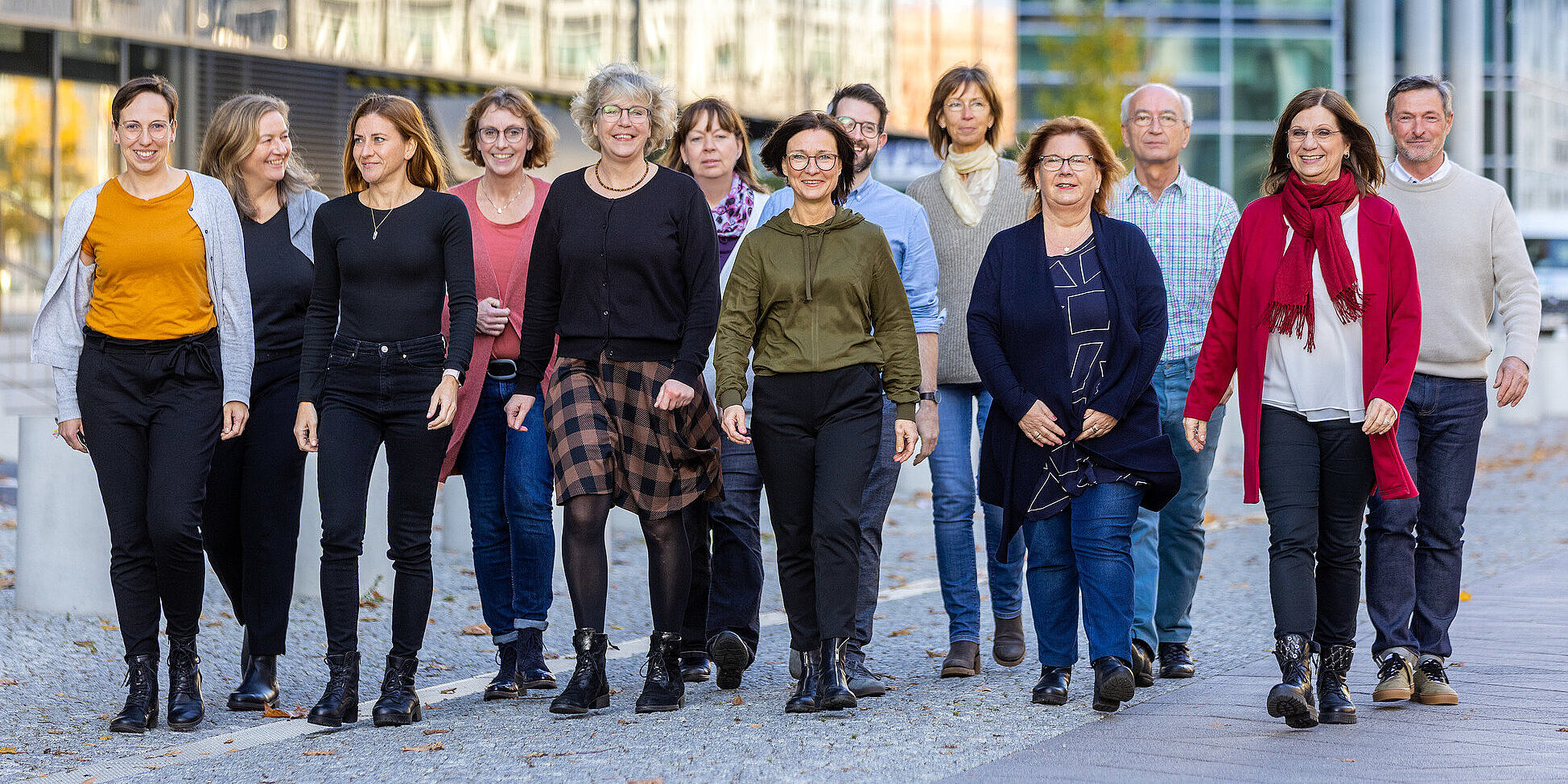 Fünfzehn Personen laufen nebeneinander auf einer Straße.