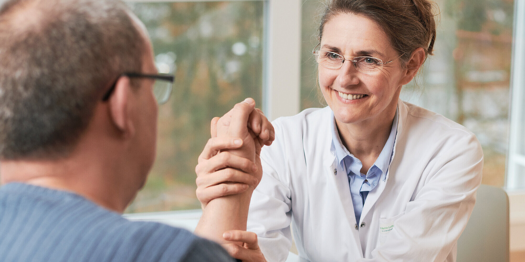 Ärztin in einem Beratungsgespräch mit einem Patienten.