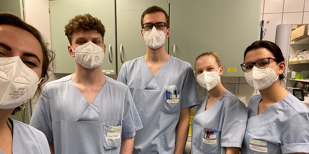 Gruppenfoto von fünf Auszubildenden in Dienstkleidung