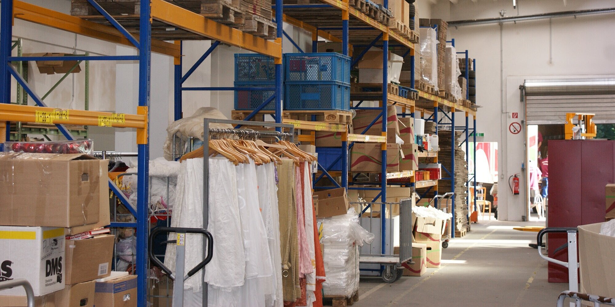 Fundgrube: Sachspenden für das Second-Hand-Kaufhaus Eine Lagerhalle mit hohen Regalen, in denen Waren gelagert werden.