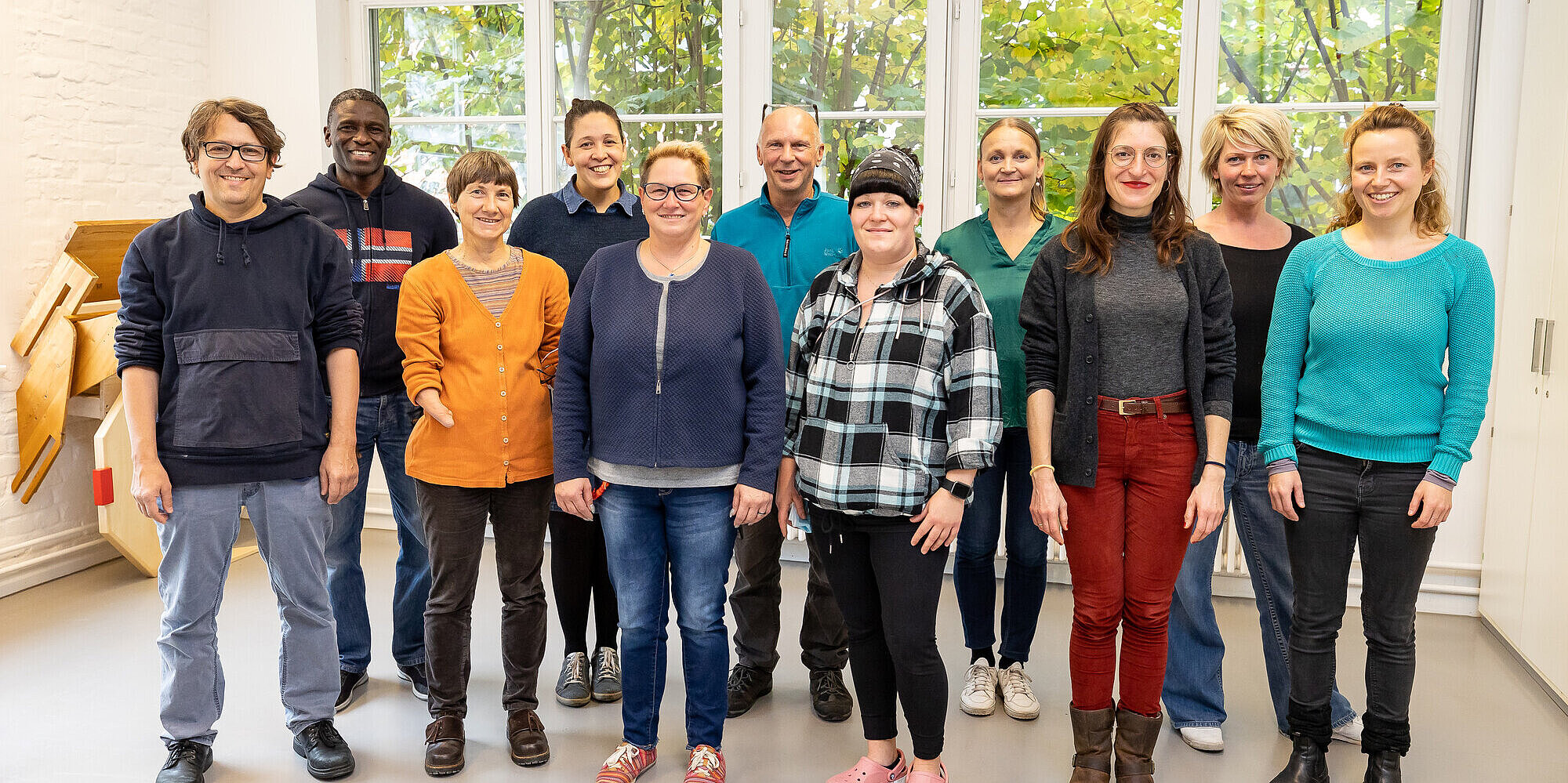 Mehrere Menschen stehen für ein Teamfoto nebeneinander.