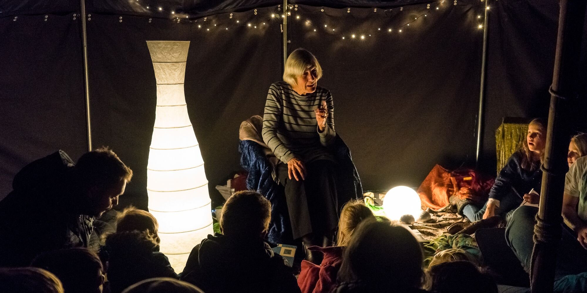 Eine Frau erzählt Kindern in einem Zelt eine Geschichte.