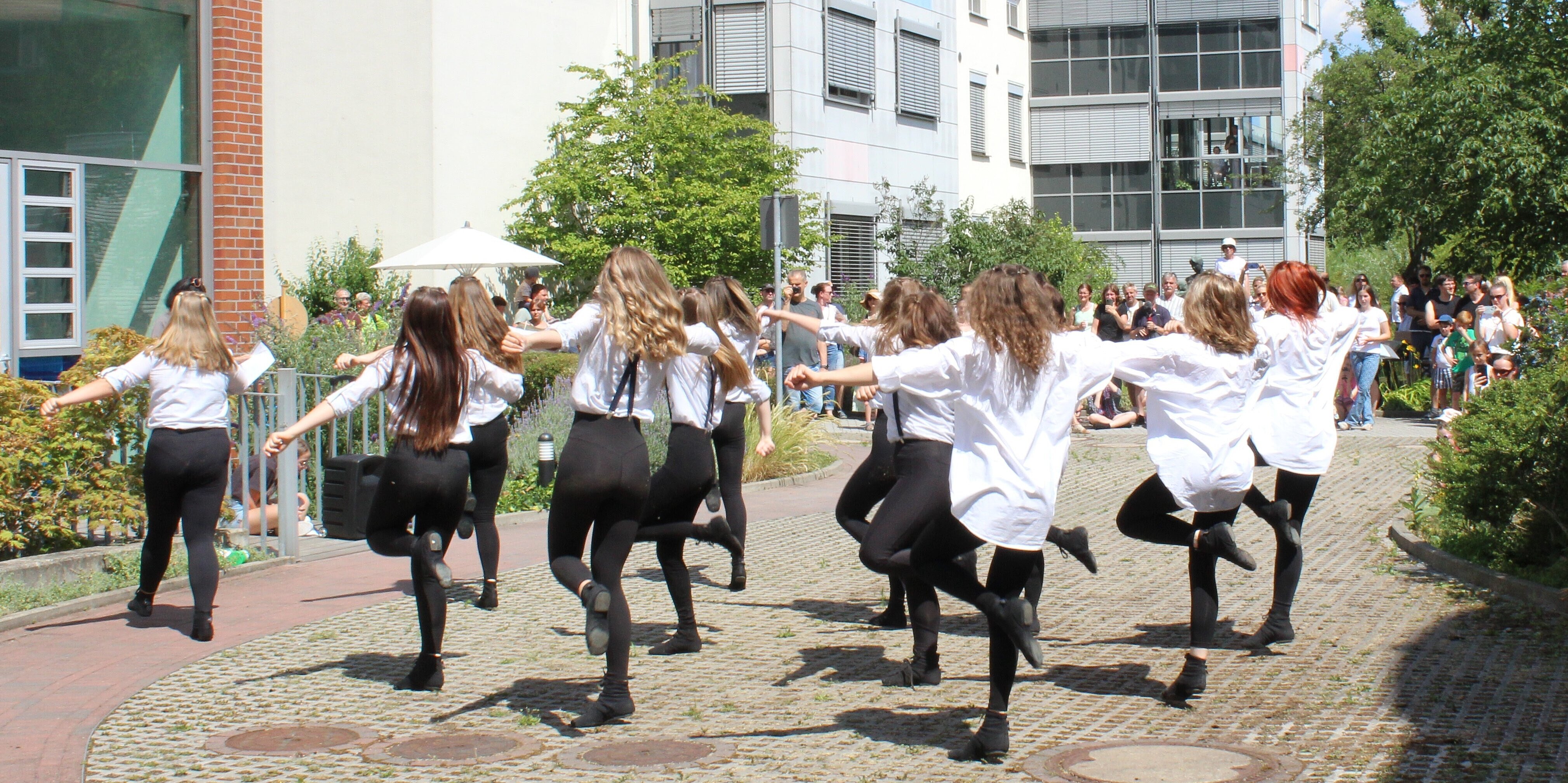Kinder tanzen vor dem Eingang des Hospizes