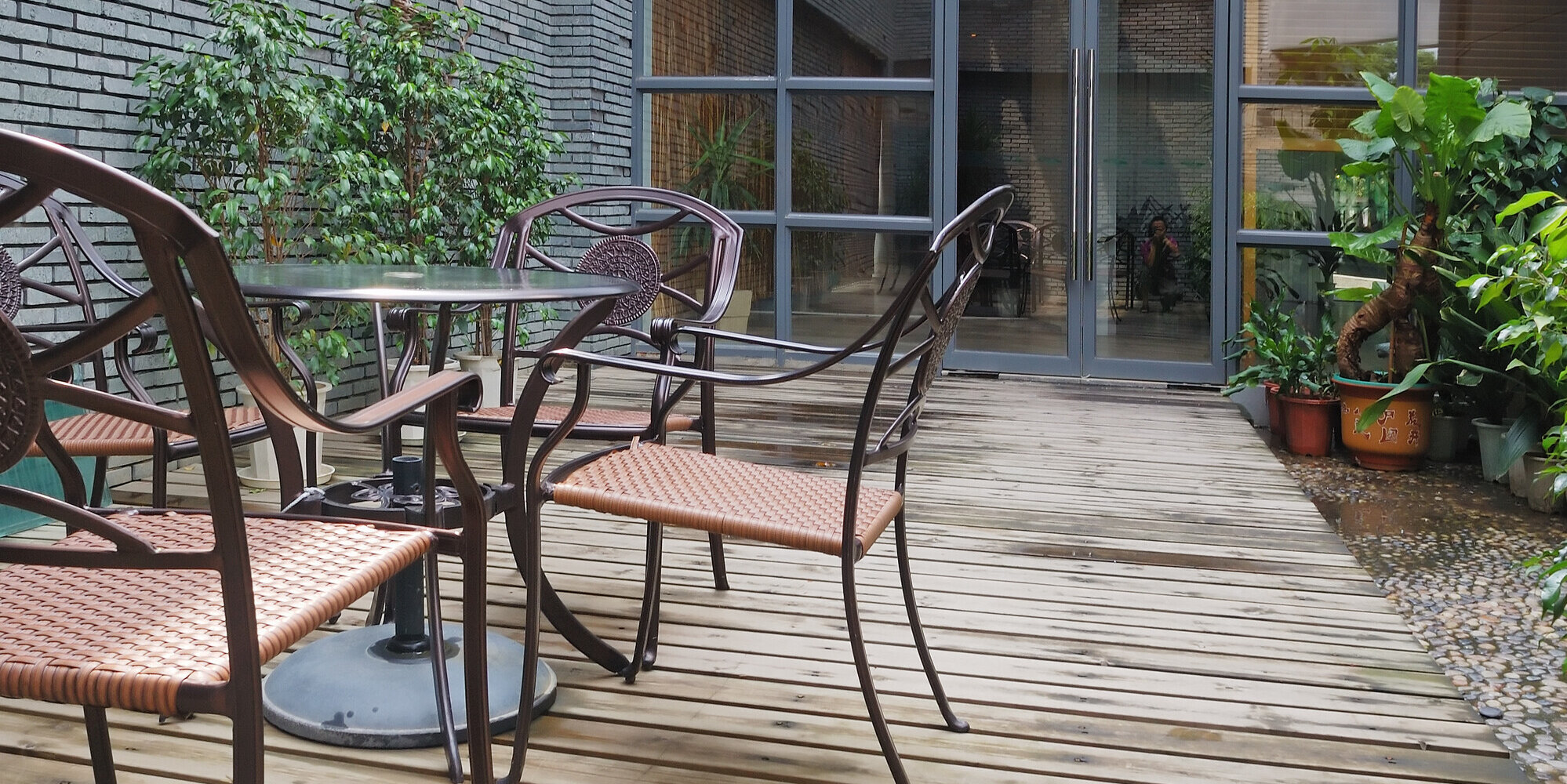 Eine Terrasse mit Holzboden sowie Stühlen und einem Tisch.