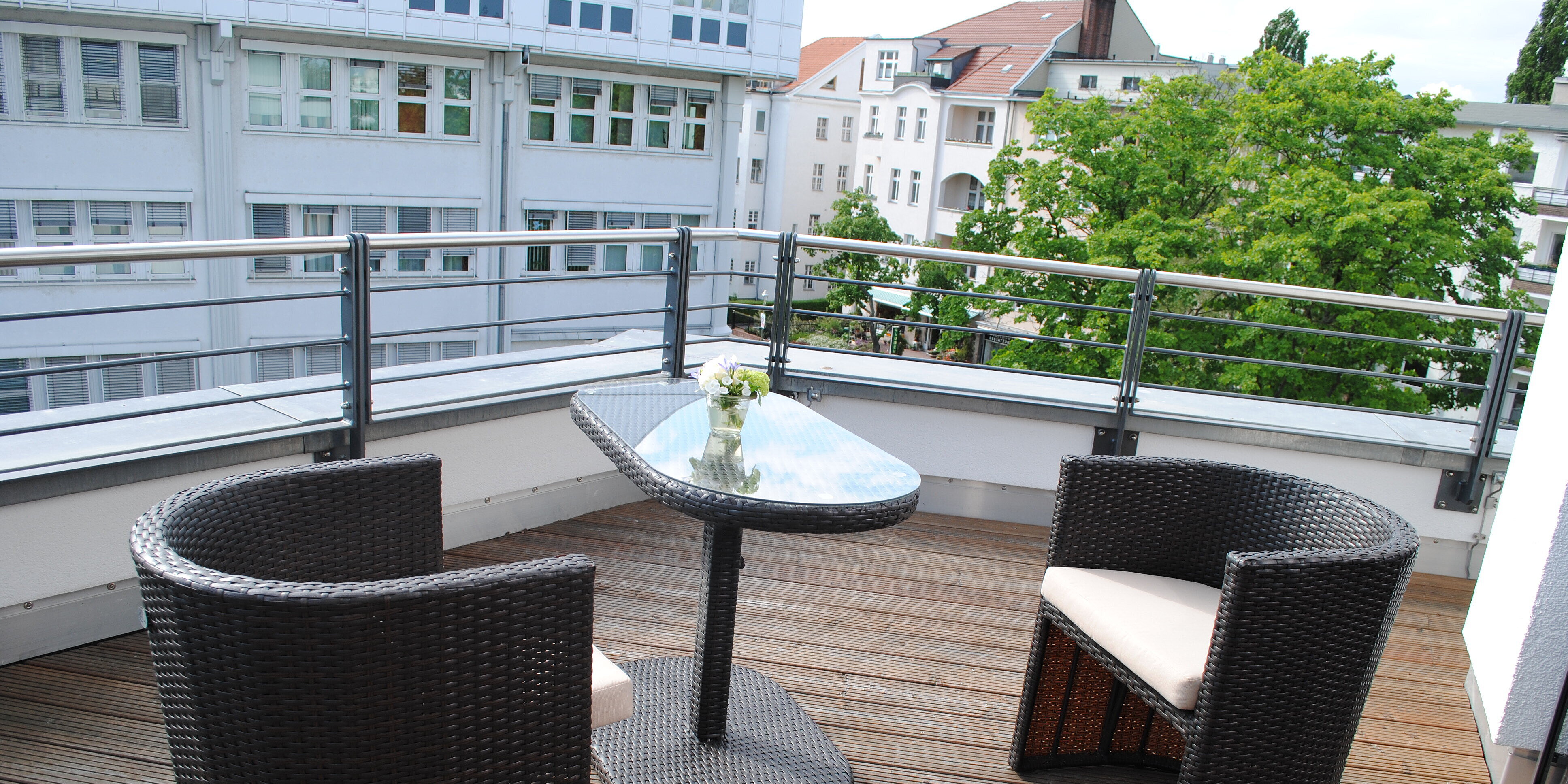 Terrasse mit Holzfußboden und Sitzmöglichkeiten sowie einem Tisch.