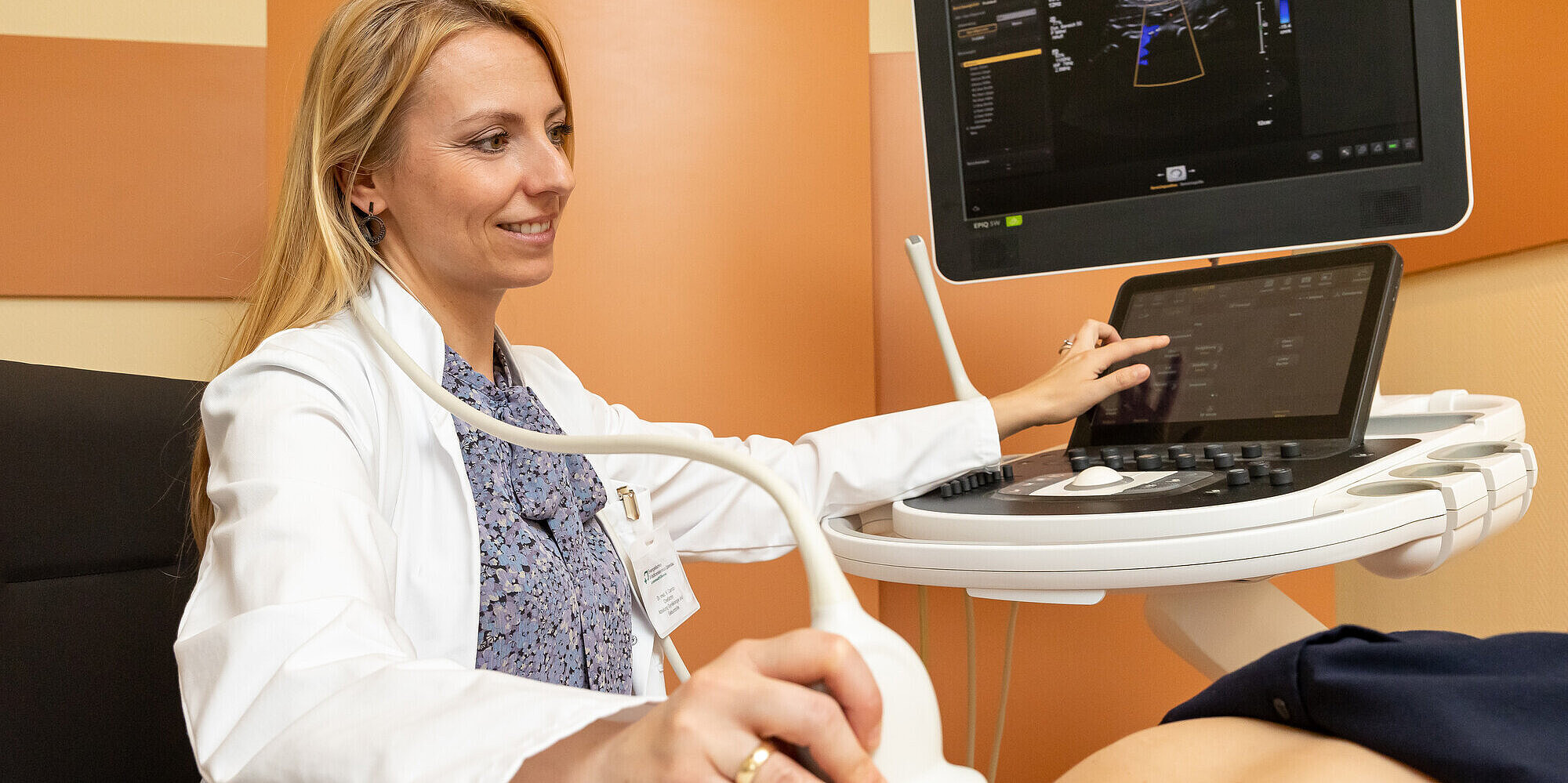 Ärztin untersucht Patientin am Bauch.
