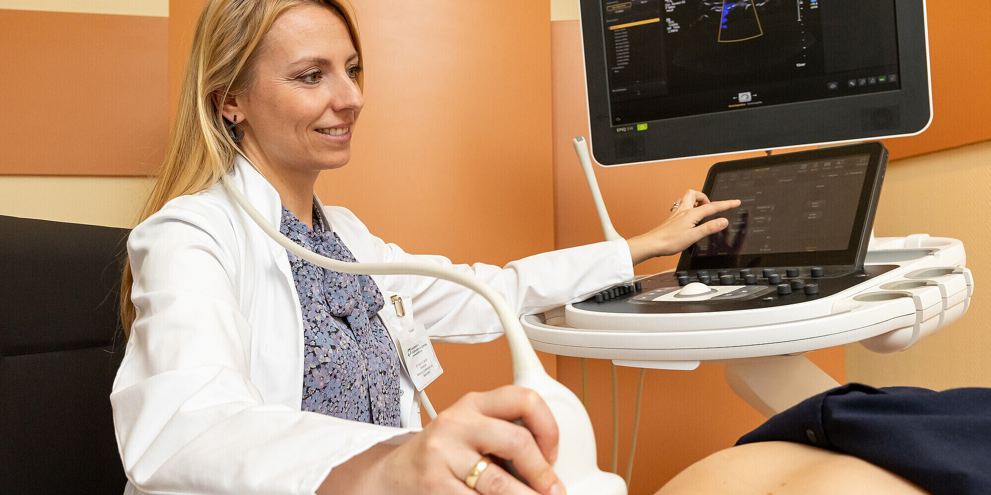 Ärztin untersucht Patientin am Bauch.