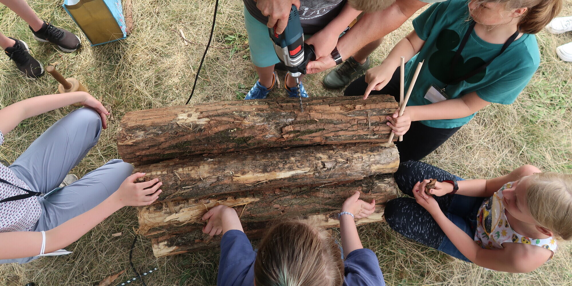 Kinder bohren in ein Stück Holz