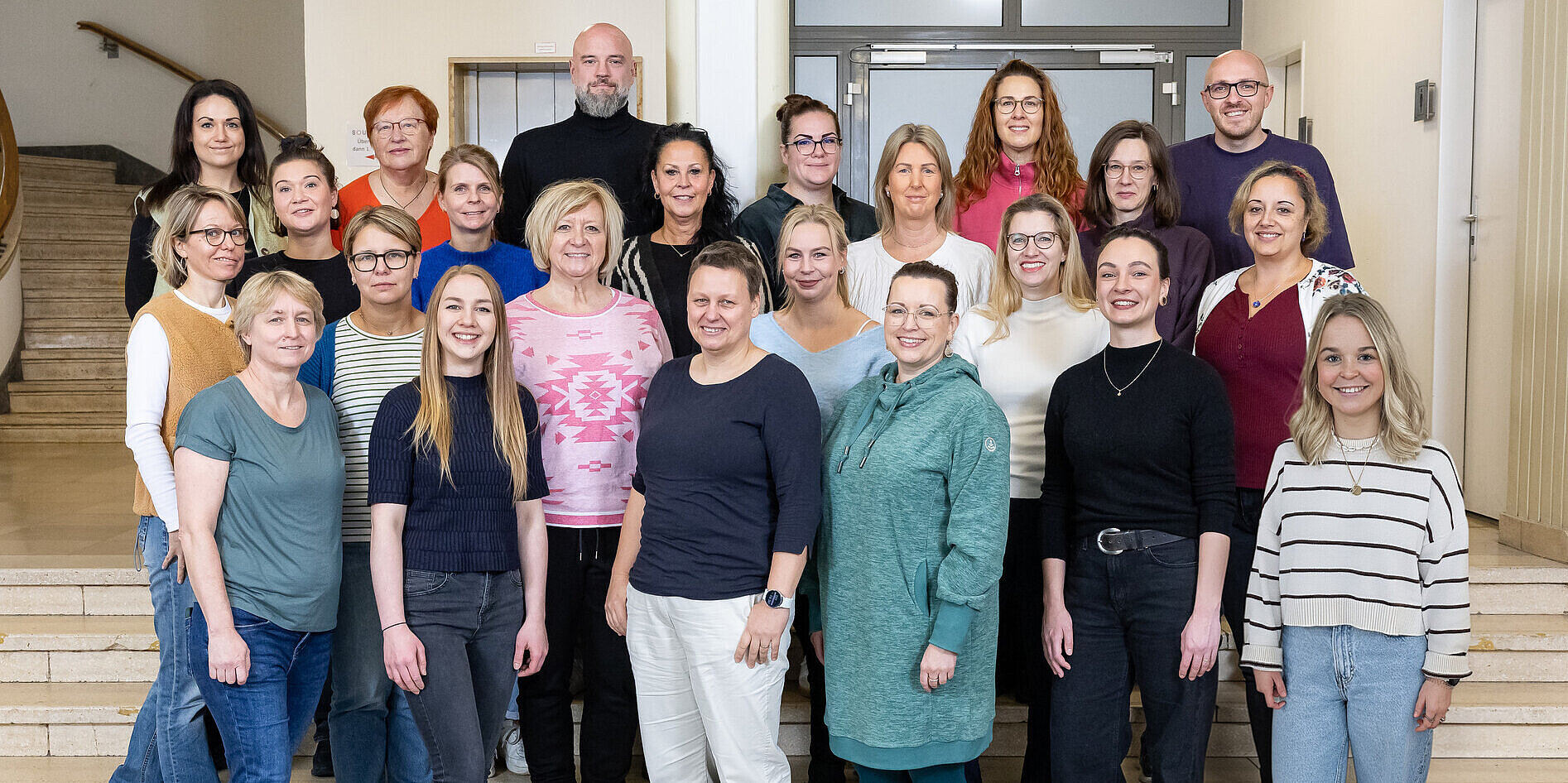20 Lehrerinnen stehen vor der Schule.