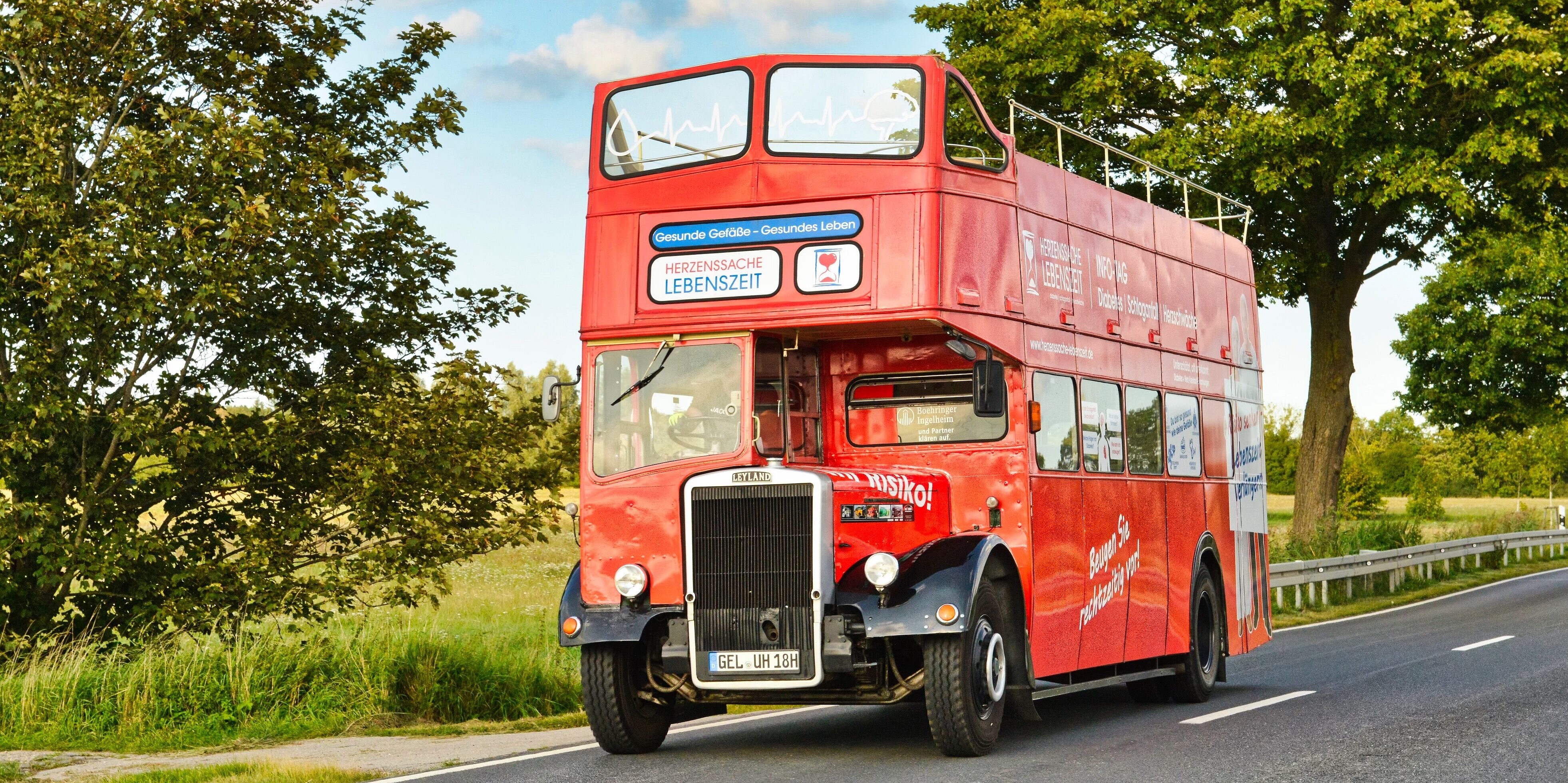 Bild des zweistöckigen roten Oldtimer Buses auf einer Landstraße