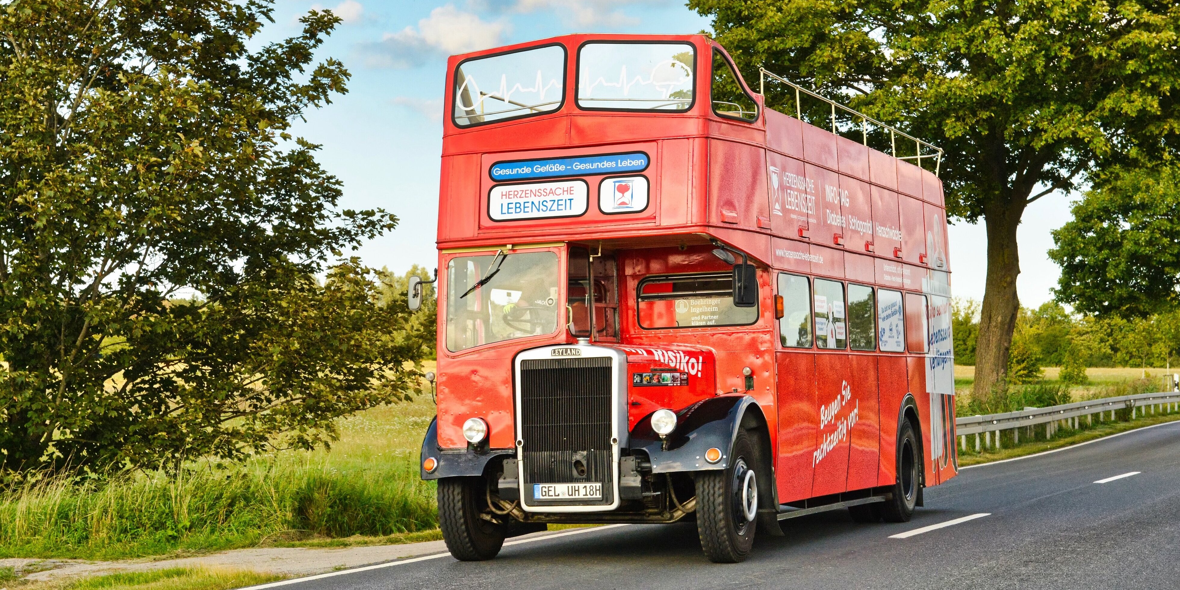 Herzbus kommt nach Coswig: Testen Sie Ihr Risiko für Herzschwäche, Schlafanfall & Diabetes Bild des zweistöckigen roten Oldtimer Buses auf einer Landstraße