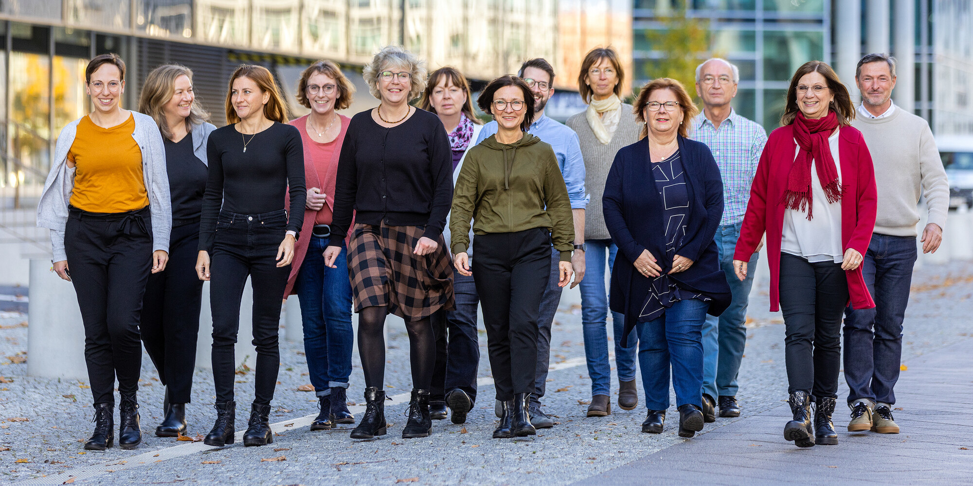 Fünfzehn Personen laufen nebeneinander auf einer Straße.