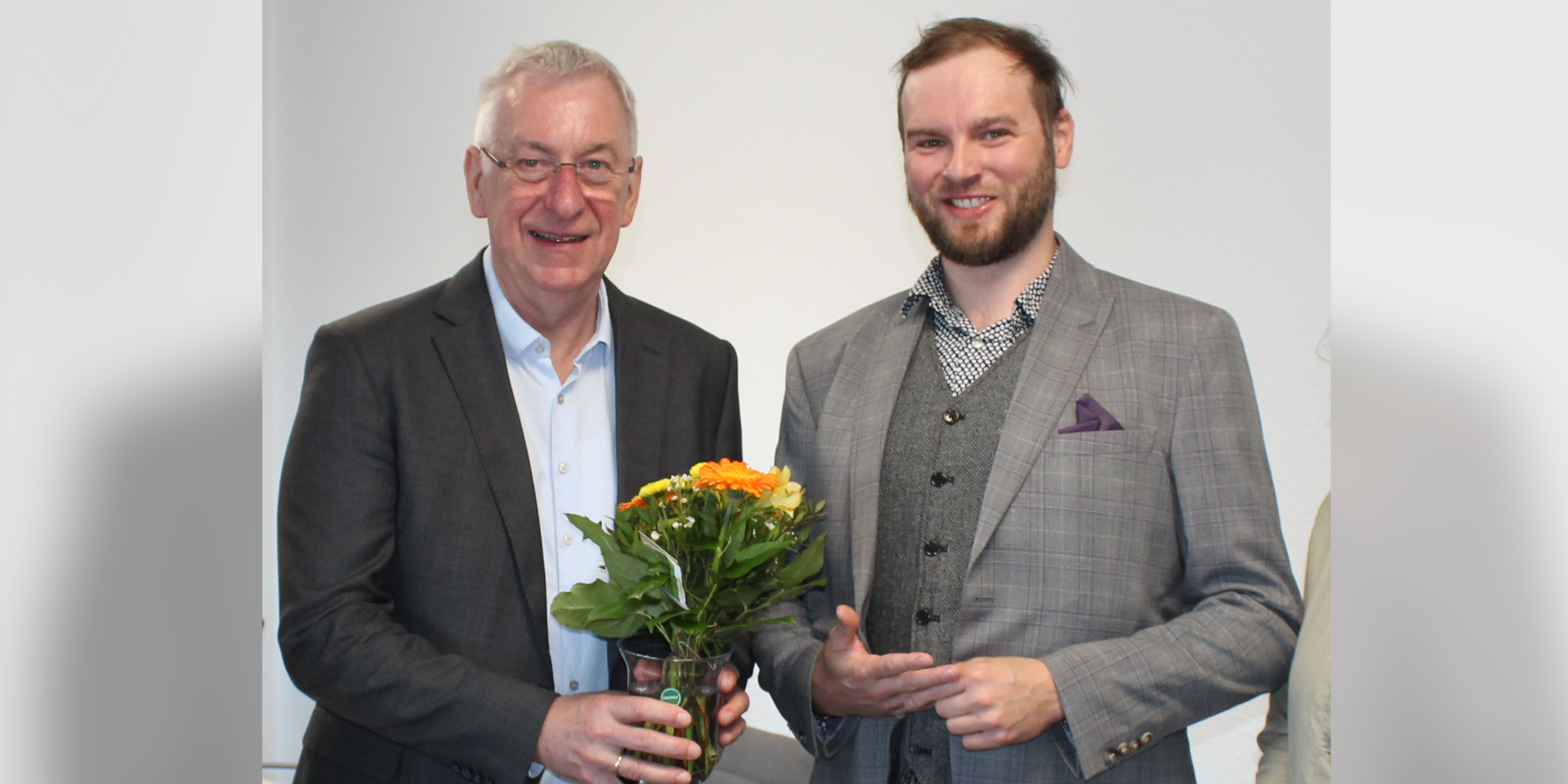 Geschäftsführer überreicht Blumen an neuen Schulleiter